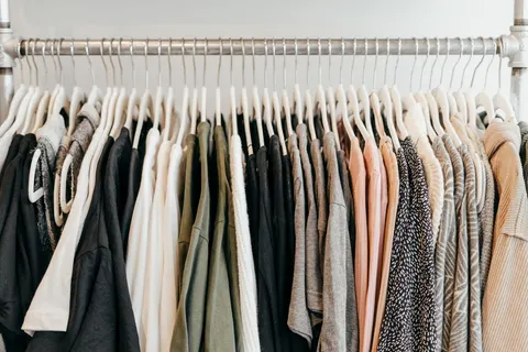 A row of clothes on hangers showing different textures and colors.